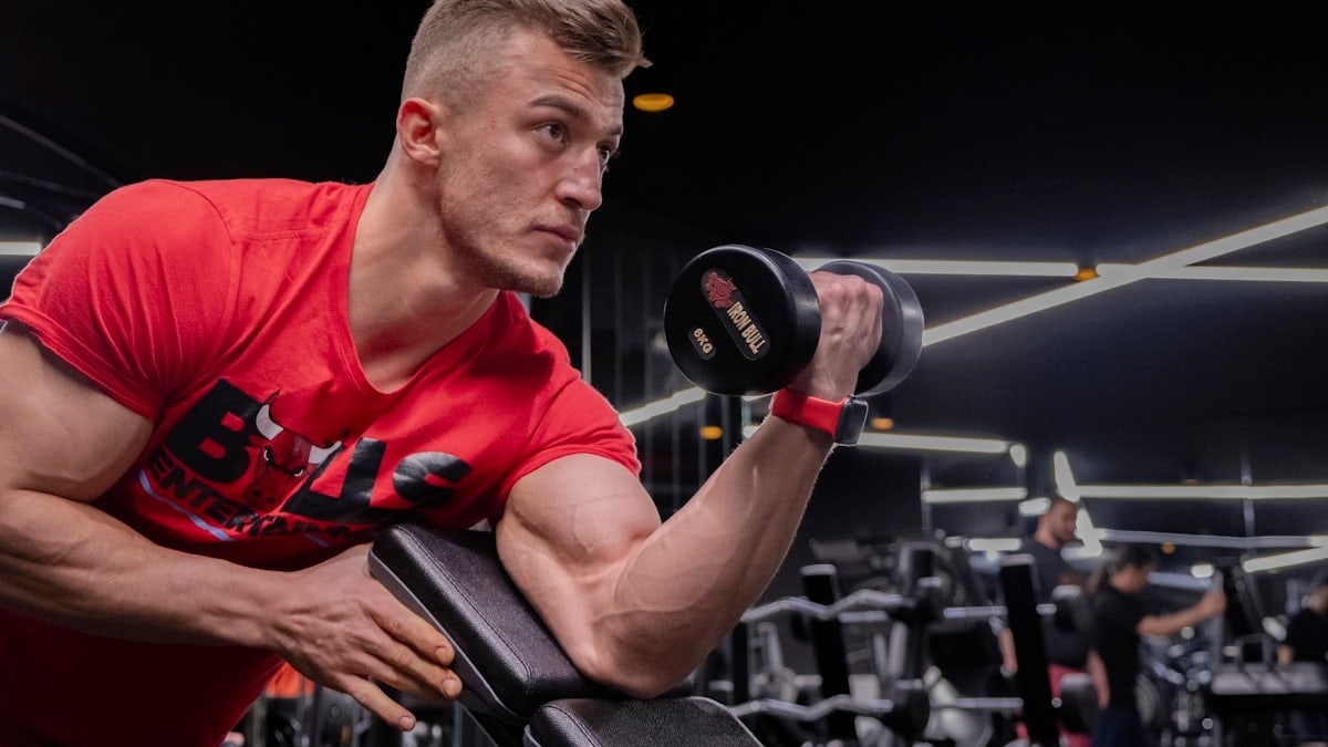 a man in a gym holding a dumbbell